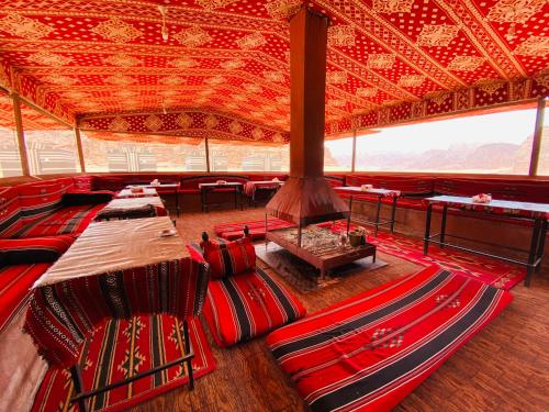 瓦迪拉姆Bedouin Memories Camp的一间设有红色椅子和大型天花板的客房