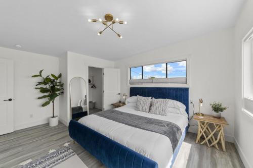 Driftwood ShoresNew DRIFTWOOD SHORES ROAD HOUSE CAMANO的卧室配有蓝色和白色的床和窗户。