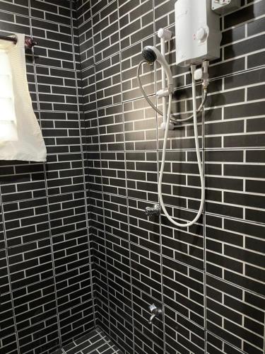 辛加东卡Two Bedroom Holiday Home- Olosara Sigatoka Guest House的浴室铺有黑色瓷砖,设有淋浴。