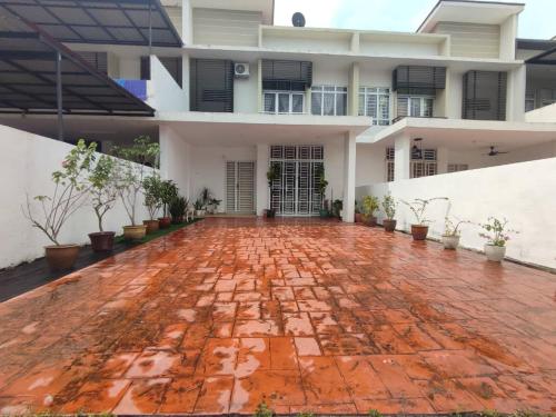 新山Dhana Palace Homestay Gelang Patah的一座白色的大房子,有红砖庭院