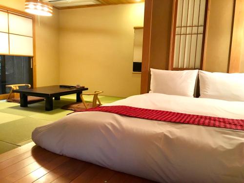 伊东Toushinan Komeya的一间卧室配有一张大床和一张桌子