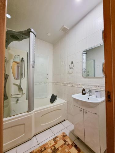 阿斯塔纳Квартира的带浴缸、水槽和淋浴的浴室