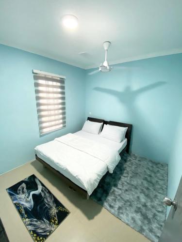 哥打丁宜Baiduri Homestay的一间卧室配有一张蓝色墙壁的床