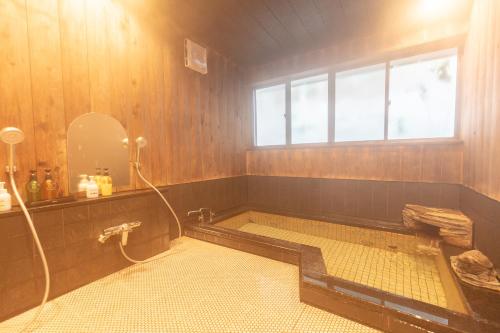 秩父市Ryokan Hiyoshi的带浴缸和窗户的浴室