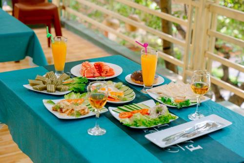宁平Mai Mountain Homestay的蓝色桌子,上面放有食物和橙汁