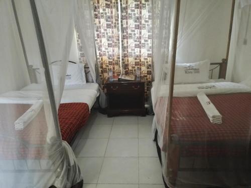 纳库鲁基伍度假酒店的带窗户的客房内的两张床