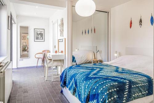 切尔滕纳姆Gorgeous 1BD Balearic-style home with Gardens的一间卧室配有一张床、一张桌子和一张书桌