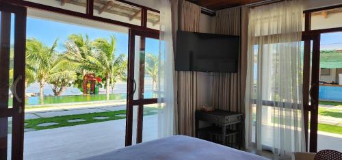 潘郎Myhoa Lagoon - Kiting Town的一间卧室设有一张床和一个大型玻璃窗