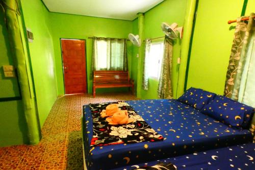 Ban Ao YaiAo Yai Homestay的客厅设有蓝色的沙发和绿色的墙壁。