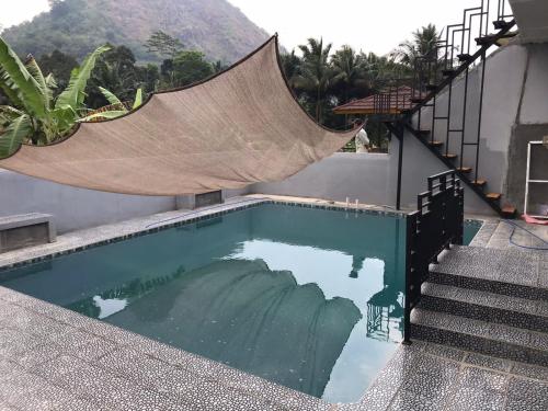 茂物Vila Gunung Batu inces的房屋一侧带吊床的游泳池