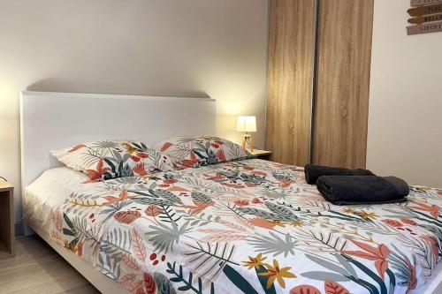 帕拉瓦莱弗洛Appartement calme, climatisé 3min à pied de la mer的一间卧室配有一张带五颜六色棉被的床