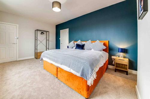 巴恩斯利The Collier's Rest: 3 bed home in South Yorks with parking & garden.的一间卧室设有一张大床和蓝色的墙壁