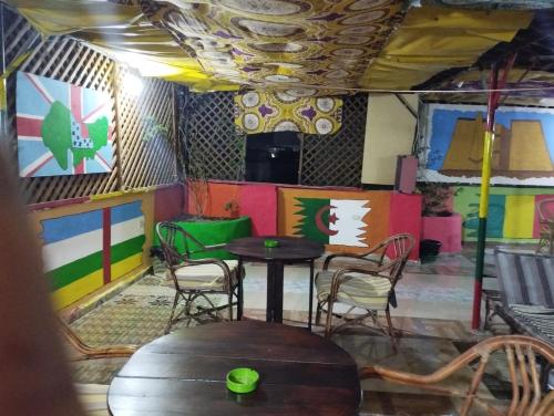 卢克索Bob Marley Peace hostels luxor的色彩缤纷的墙壁里一张桌子和椅子