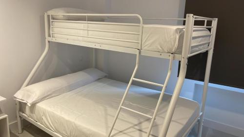 马德里C7 Exclusiva zona Madrid的小客房内的一张白色双层床