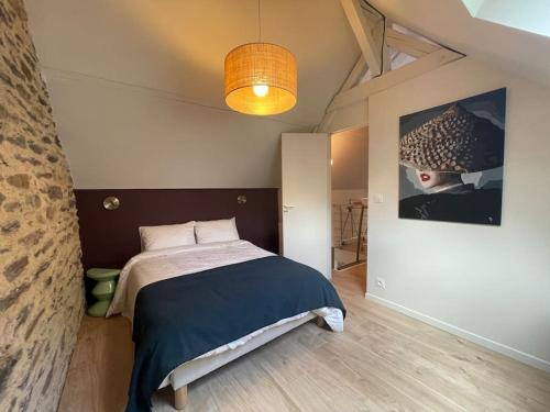 雷恩Maison du Thabor的卧室配有一张床,墙上挂有绘画作品