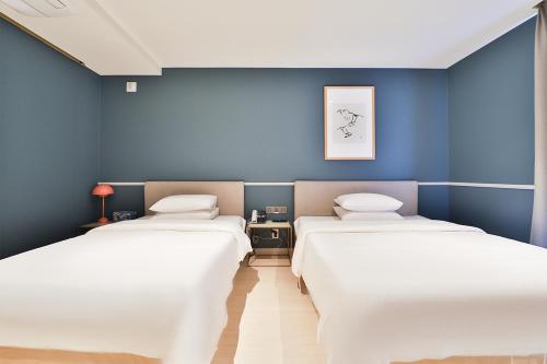 蔚山Brown Dot Hotel Ulsan Samsan的蓝色墙壁客房的两张床