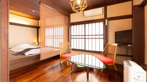 秩父市Ryokan Hiyoshi的卧室配有一张床和一张桌子及椅子