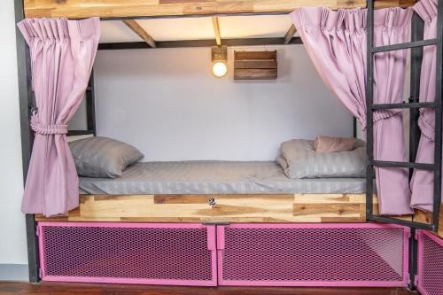 拜县K-Bunk Hostel Pai Walking Street的配有粉红色床架的客房内的双层床