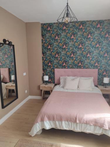 曼萨纳雷斯DIVINA GUEST HOUSE的一间卧室设有粉红色的床和花卉墙