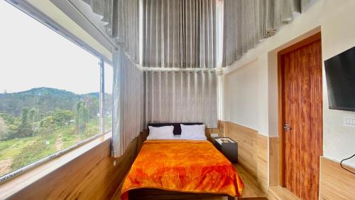 科代卡纳尔Willostays BlessedBlooms kodaikanal的一间卧室设有一张大床和大窗户