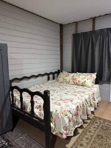 瓜拉丁加奴Haji Othman Farm的一间卧室配有一张带花卉棉被的床