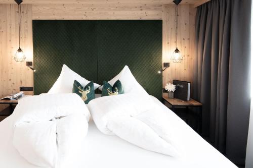 索尔登加尼柔丝迪卡酒店的一间卧室配有一张白色床和绿色床头板