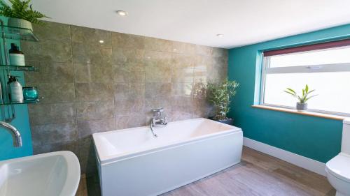 莫法涅夫Cae Calch的浴室设有白色浴缸和绿色墙壁。