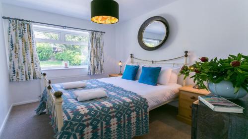 莫法涅夫Cae Calch的一间卧室配有一张带蓝色枕头和镜子的床