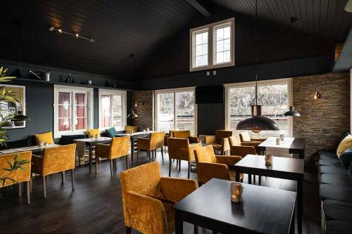 特韦德斯特兰Tvedestrand Fjordhotell - Unike Hoteller的用餐室设有桌椅和窗户。