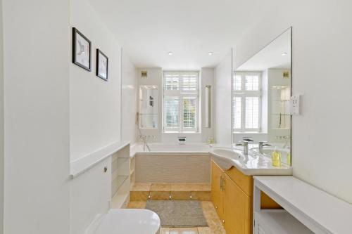 伦敦3 Bedroom Mews Home - Clapham Common - Free Private Parking - Sleeps 5 - Newly Refurbished - Sweetpea & Pillow Properties的白色的浴室设有浴缸和水槽。