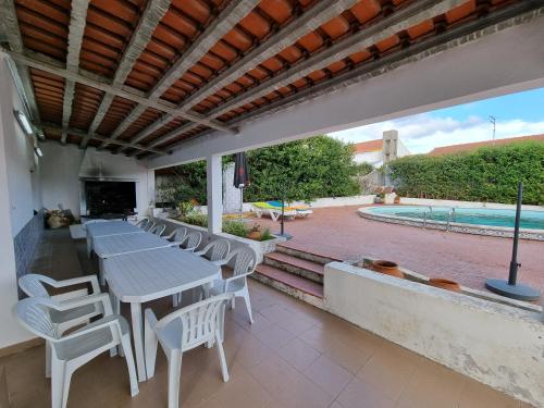 塞图巴尔Quinta D'Avó的一个带桌椅的庭院和一个游泳池