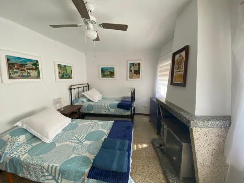 埃尔阿雷纳尔Arenalita的一间卧室设有两张床和一个壁炉