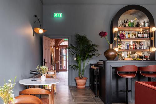 都柏林Number 59 Dublin的餐厅设有酒吧,配有桌椅