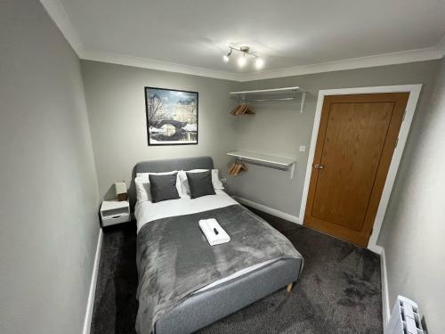 卡迪夫Ultra-Luxury City centre 2 bed apartment, with FREE parking的一间卧室配有一张床和一扇木门