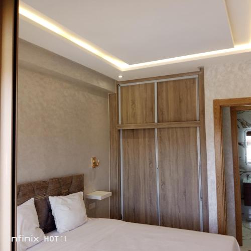 曼苏里亚Málaga beach el mansouria的一间卧室配有一张床和一个木制橱柜