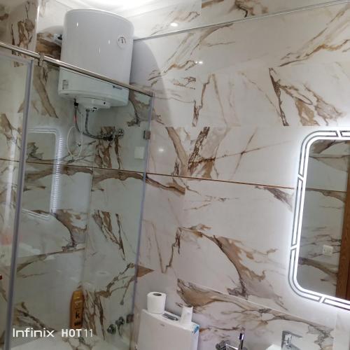 曼苏里亚Málaga beach el mansouria的浴室设有白色大理石墙壁和镜子