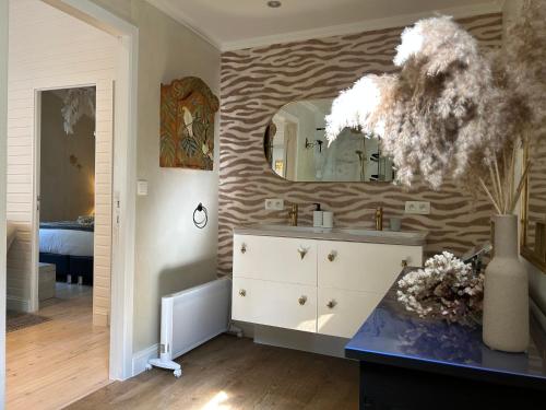 聚滕达尔Chalet Maurice的浴室设有水槽和墙上的镜子