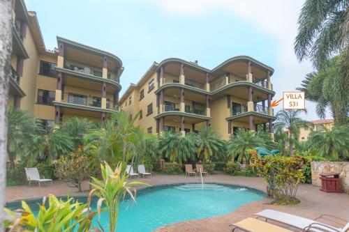 罗阿坦Pineapple Villa 531 condo的一座带游泳池的度假村,位于一座建筑前