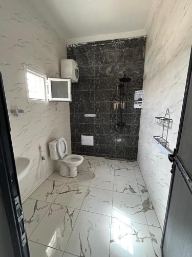 努瓦克肖特AbCd的白色的浴室设有卫生间和水槽。