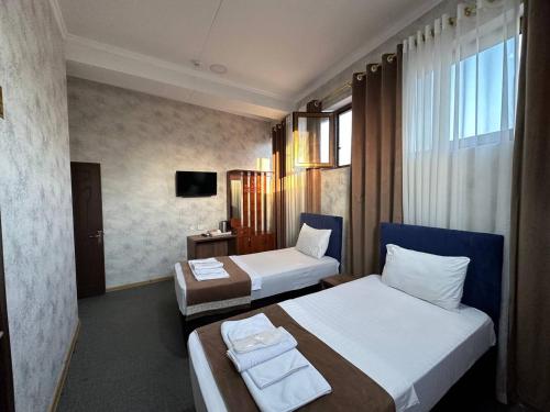 塔什干Al Arda Avenue的酒店客房设有两张床和电视。