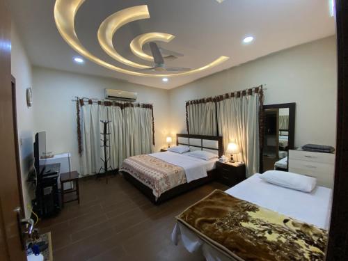 拉瓦尔品第Alpha Guest House的酒店客房设有两张床和圆形天花板。