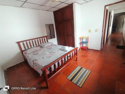 圣玛尔塔Hospedaje Doña Victoria的卧室配有一张床,铺有红色瓷砖地板。