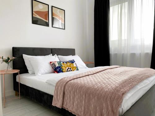 布加勒斯特Orhideea Central Apartments的一间卧室设有一张床和一个窗口