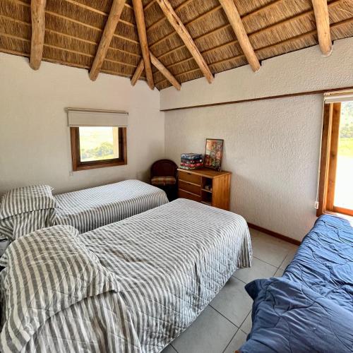 里韦拉Casa de campo的一间卧室设有两张床和木制天花板