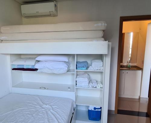 马蒂尼奥斯Apto completo praia Caioba的一间卧室配有双层床和一张白色双层床。