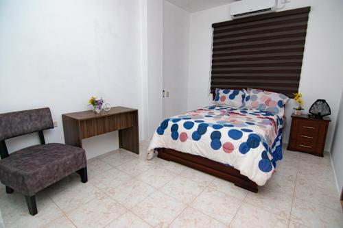 曼塔Habitaciones privadas, Casa de Amber, Manta的一间卧室配有一张床和一把椅子
