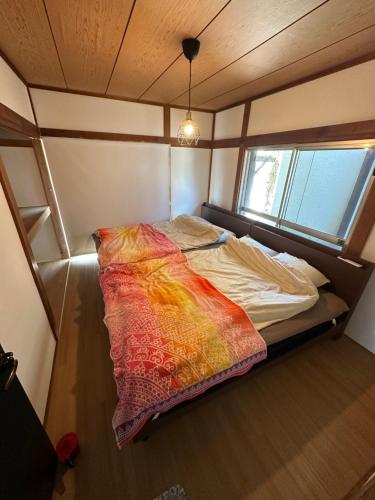 NishinaMonster lodge 西伊豆的一个小房间的一个床位,设有窗户