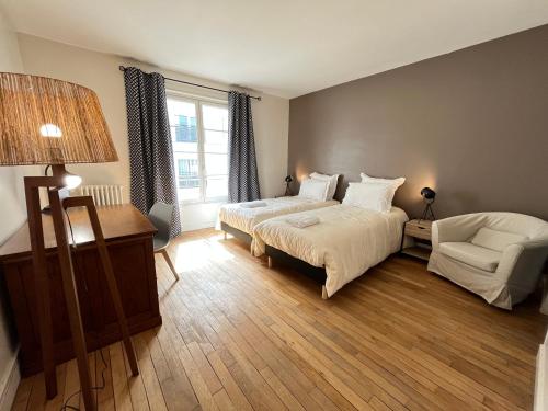 勒芒La Villa Maignan - Centre ville - Jardin - 15p的卧室配有床、椅子和窗户。