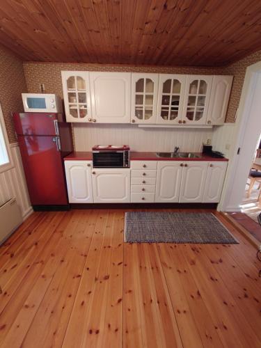 马尔默Villa Naffen1的厨房配有白色橱柜和红色冰箱
