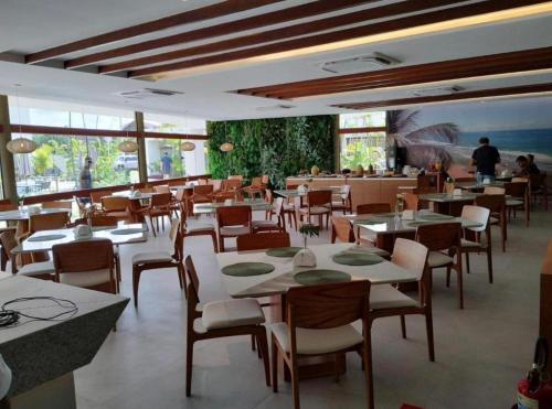 伊波茹卡Mana Beach Experience的餐厅设有桌椅,背景人员